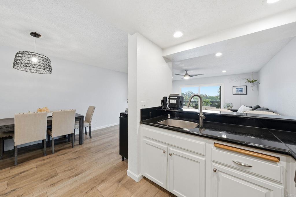3711 Balboa Terrace, Unit B San Diego, CA 92117 - Photo 13 of 39 a kitchen with a sink dishwasher a dining table and chairs with wooden floor