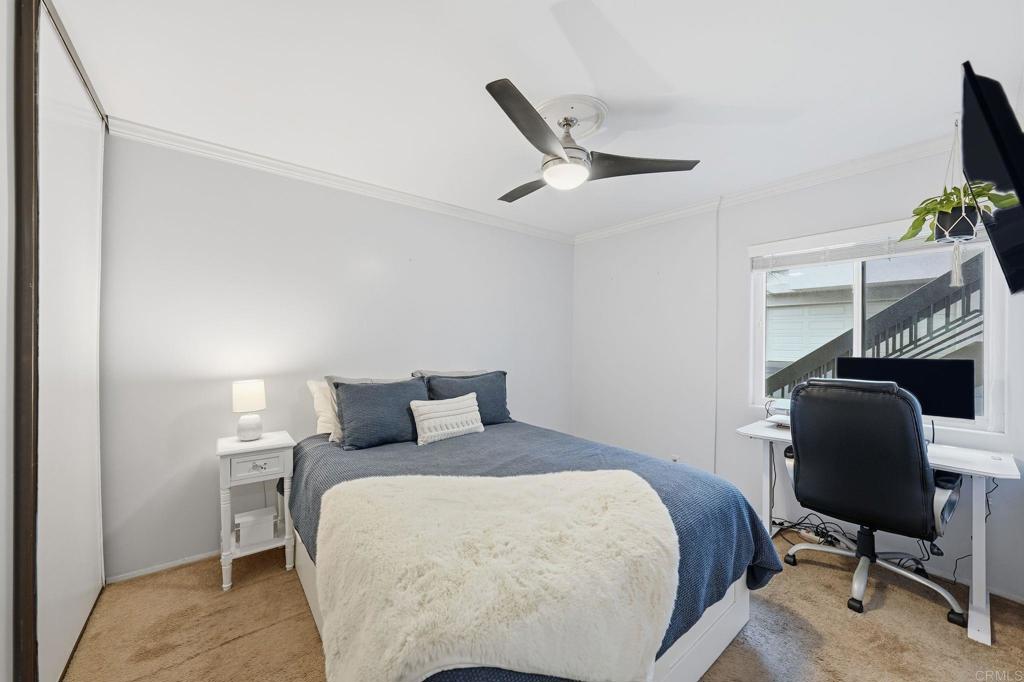 3711 Balboa Terrace, Unit B San Diego, CA 92117 - Photo 22 of 39 a bedroom with a bed a chair and a flat screen tv