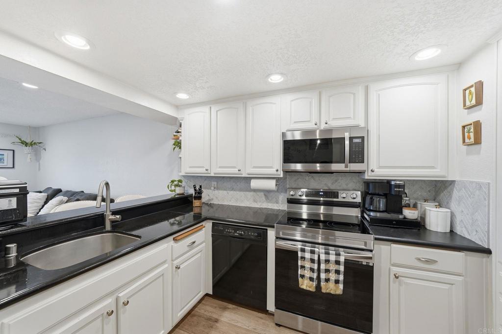 3711 Balboa Terrace, Unit B San Diego, CA 92117 - Photo 8 of 39 a kitchen with stainless steel appliances granite countertop a sink stove and microwave