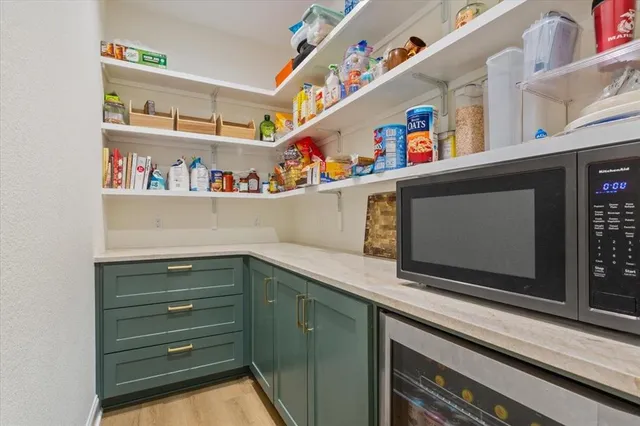 a utility room with stainless steel appliances a cabinets and window
