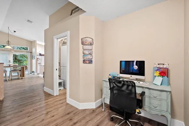 a view of a workspace with furniture and wooden floor
