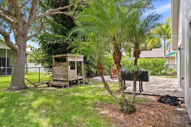 a view of a house with backyard and sitting area