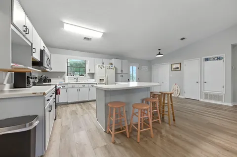 a kitchen with a white cabinets and chairs