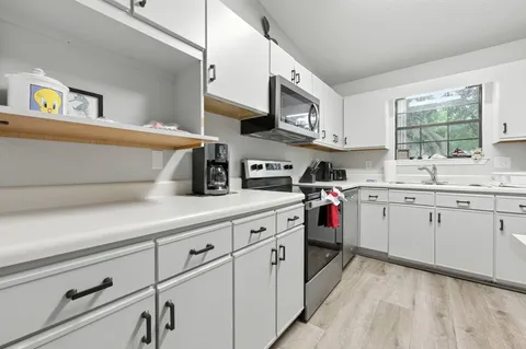 a kitchen with granite countertop cabinets stainless steel appliances and a sink