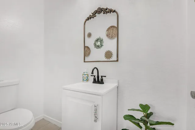 a bathroom with a sink mirror and toilet