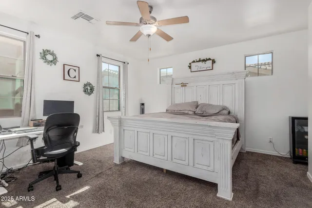 a bedroom with a bed a chair and a chandelier