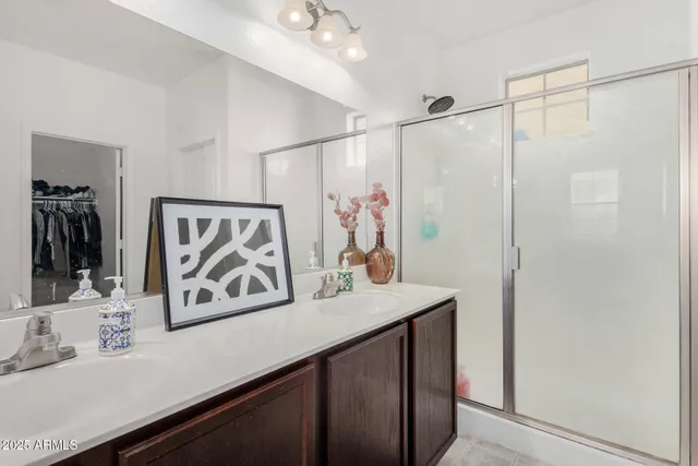 a bathroom with a sink mirror and a shower