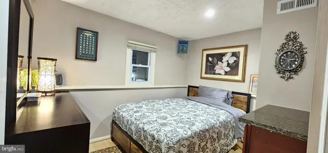 a bedroom with a bed and a dresser next to a window