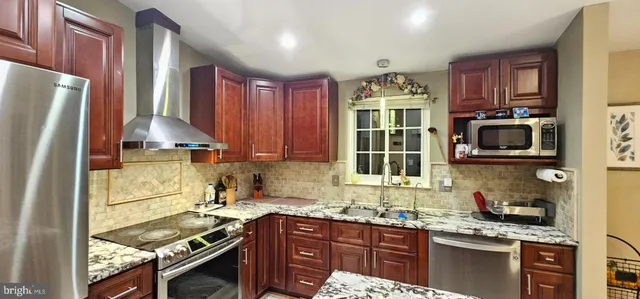 a kitchen with granite countertop a stove sink and refrigerator