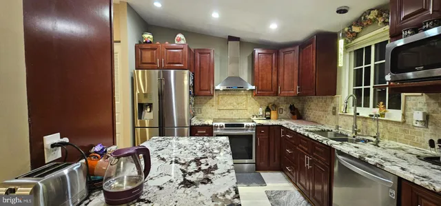 a kitchen with stainless steel appliances granite countertop a sink stove and refrigerator