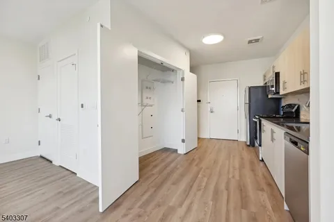 a kitchen with cabinets and wooden floor
