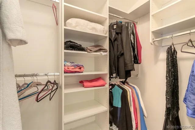 a view of walk in closet with clothes and shoes