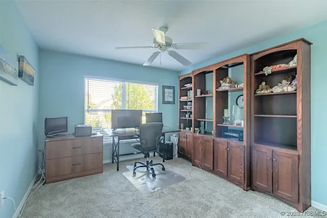 a view of a workspace with furniture and a window