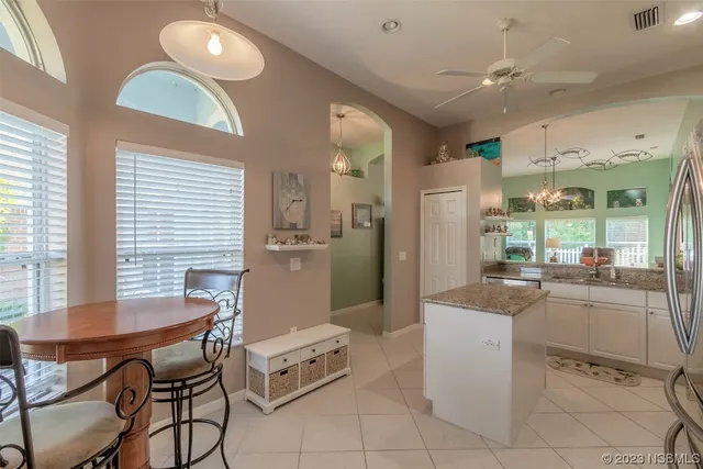 a kitchen with a dining table chairs and refrigerator