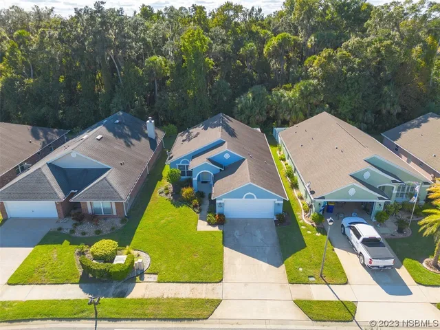 an aerial view of a house with swimming pool and large trees