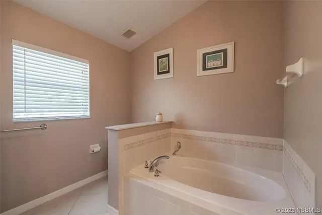 a white bath tub sitting in a bathroom next to a window