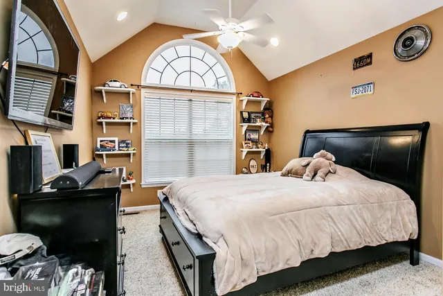 a bedroom with a bed and a flat tv screen on dresser