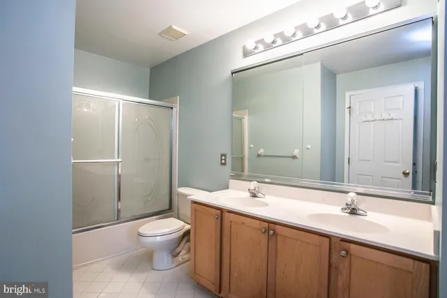 a bathroom with a toilet a sink a mirror and a shower