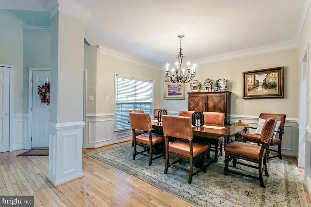 a view of a dining room with furniture a chandelier and wooden floor