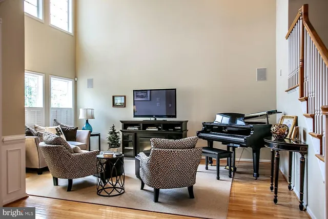 a living room with furniture a piano and a flat screen tv