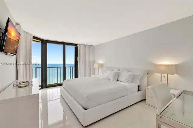 a bedroom with a balcony a bed and a flat screen tv