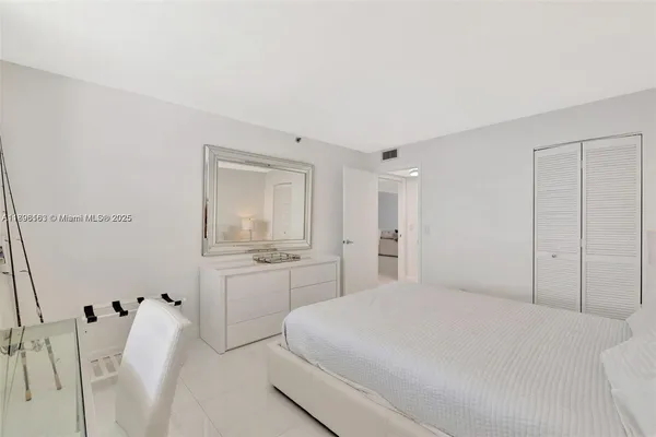 a spacious bedroom with a bed and a cabinets