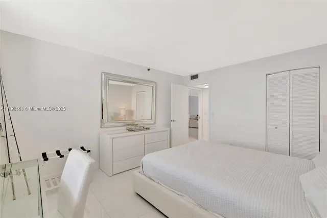 a spacious bedroom with a bed and a cabinets