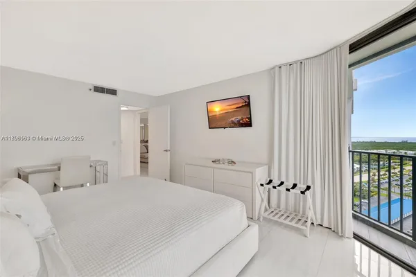 a bedroom with a bed and a tv on the dresser