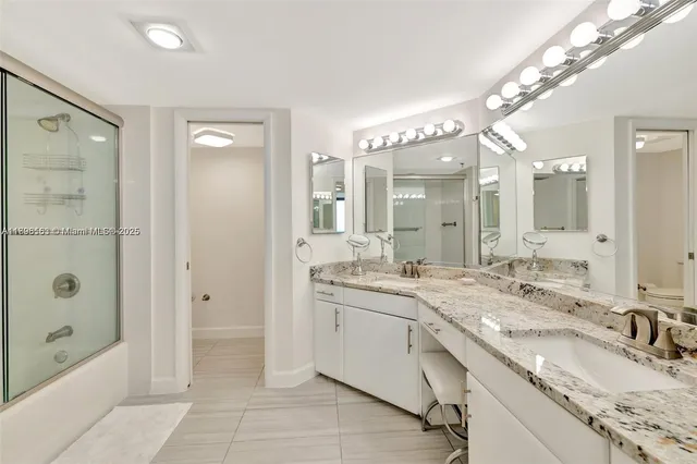 a spacious bathroom with a granite countertop sink mirror and shower