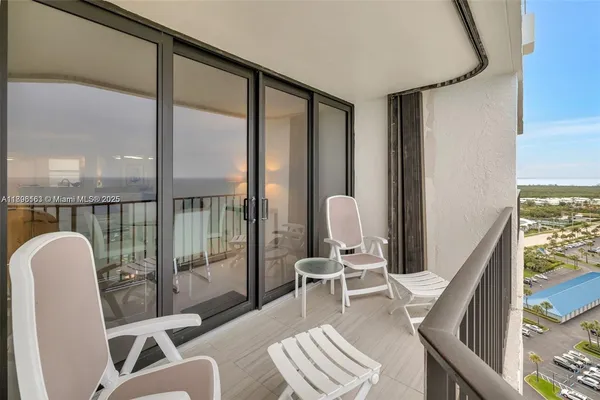 a view of a balcony with chair and potted plants