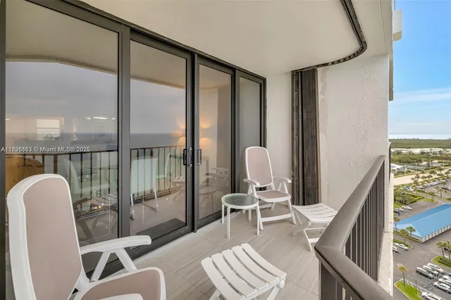 a view of a balcony with chair and potted plants
