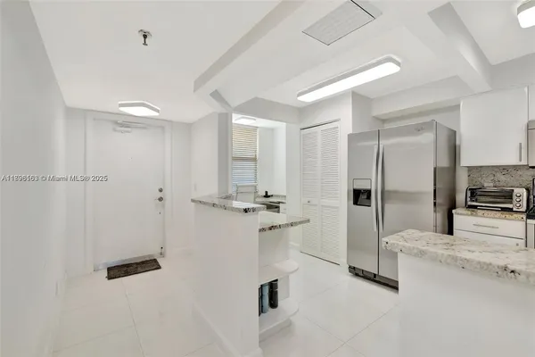 a kitchen with stainless steel appliances kitchen island a refrigerator sink and stove