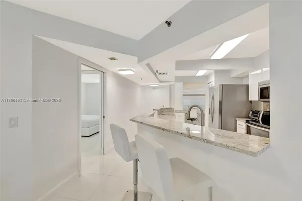 a kitchen with granite countertop a sink and white cabinets