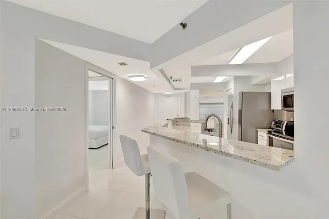 a kitchen with granite countertop a sink and white cabinets