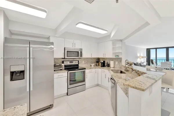 a kitchen with white cabinets and stainless steel appliances