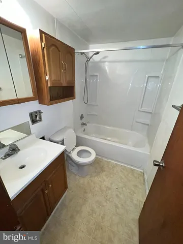 a bathroom with a sink mirror vanity and bathtub