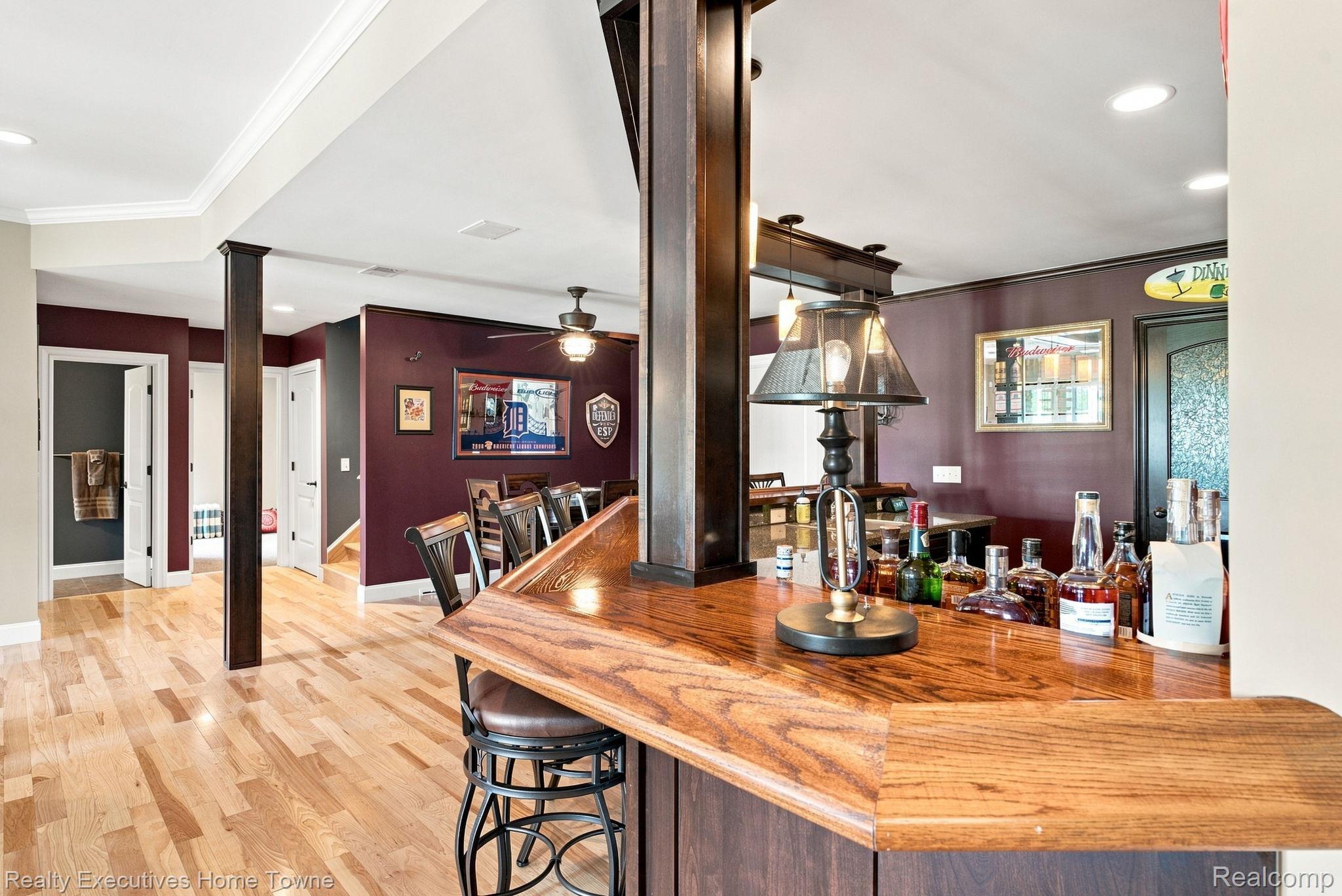 2829 Riverside Drive Port Huron, MI 48060 - Photo 42 of 99 Wood-finish flooring, built-in bar with wood countertop, recessed lighting, ceiling fan, and crown molding