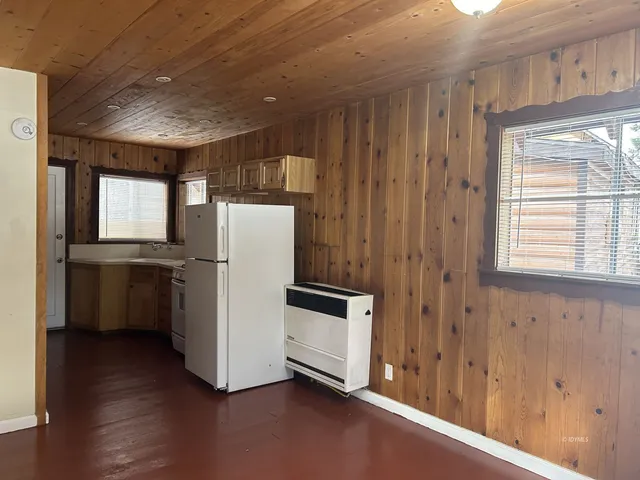 a view of a refrigerator in kitchen and wooden floor