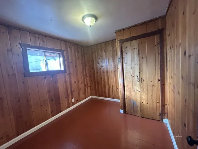an empty room with windows and closet