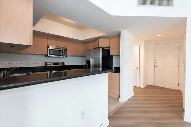 a large kitchen with stainless steel appliances a refrigerator and a stove top oven