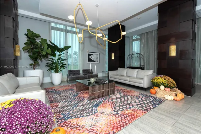 a living room with furniture rug and a chandelier