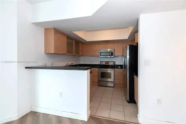 a kitchen with granite countertop a refrigerator and a stove