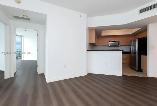 a view of a kitchen with wooden floor and a sink