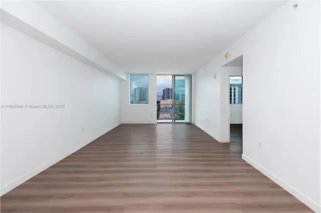 a view of empty room with wooden floor