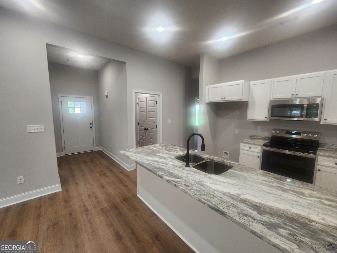 102 Silver Maple Court Byron, GA 31008 - Photo 4 of 17 a kitchen with granite countertop a sink and a stove top oven