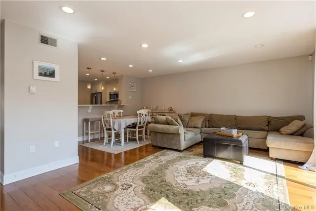 a living room with furniture and a view of kitchen