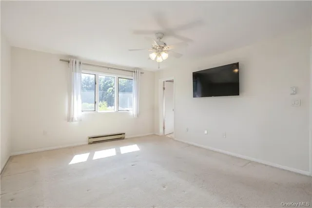 an empty room with windows and ceiling fan