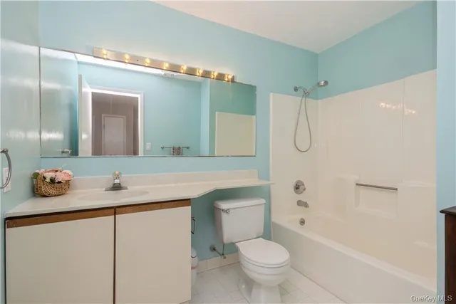 a bathroom with a granite countertop sink toilet mirror and a bathtub