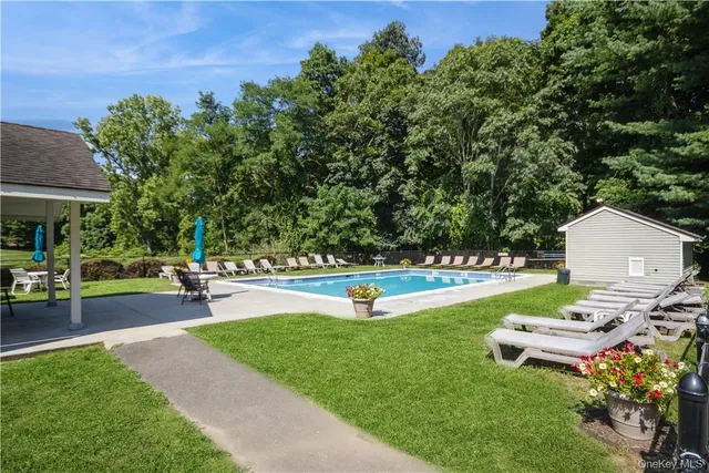 a swimming pool with outdoor seating and yard