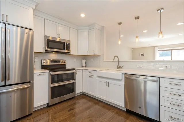a kitchen with appliances a sink and cabinets